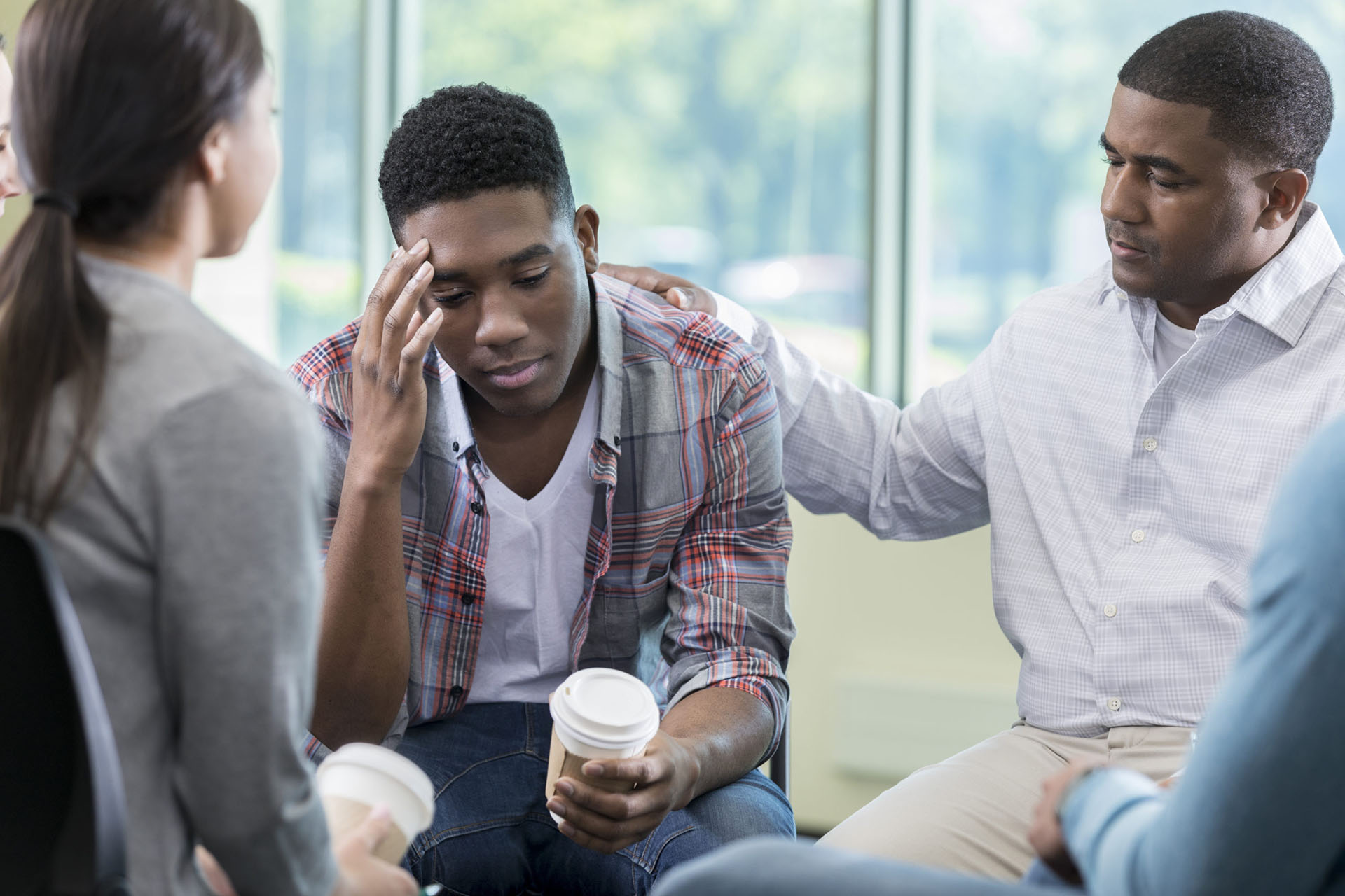 One person comforts another in a support group